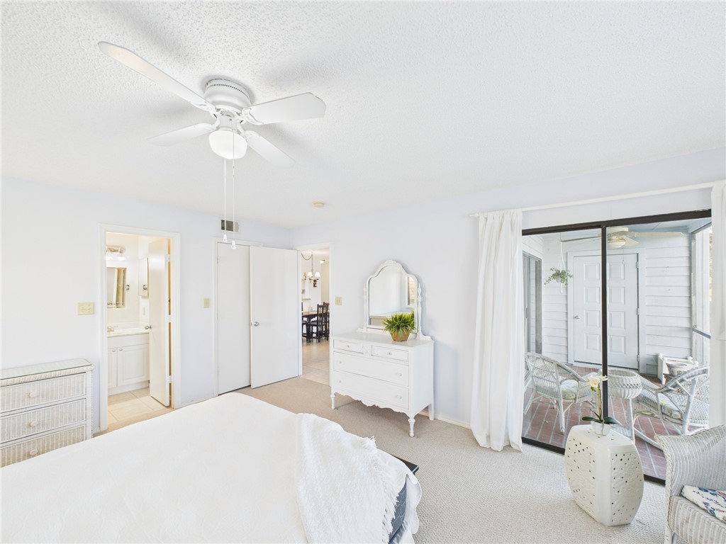 5730 Pelican Pointe Drive, Unit 2 Sebastian, FL 32958 - Photo 9 of 19 a spacious bedroom with a bed and a chandelier