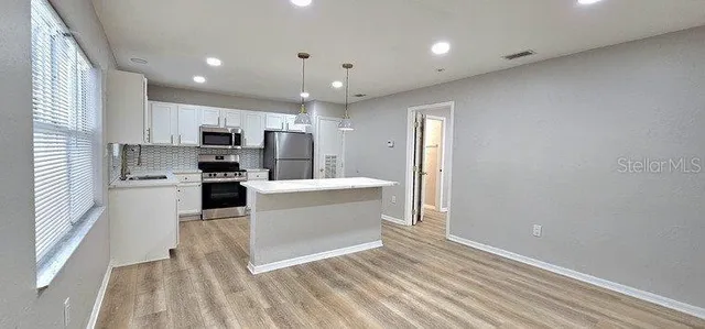 a kitchen with granite countertop a sink and white cabinets