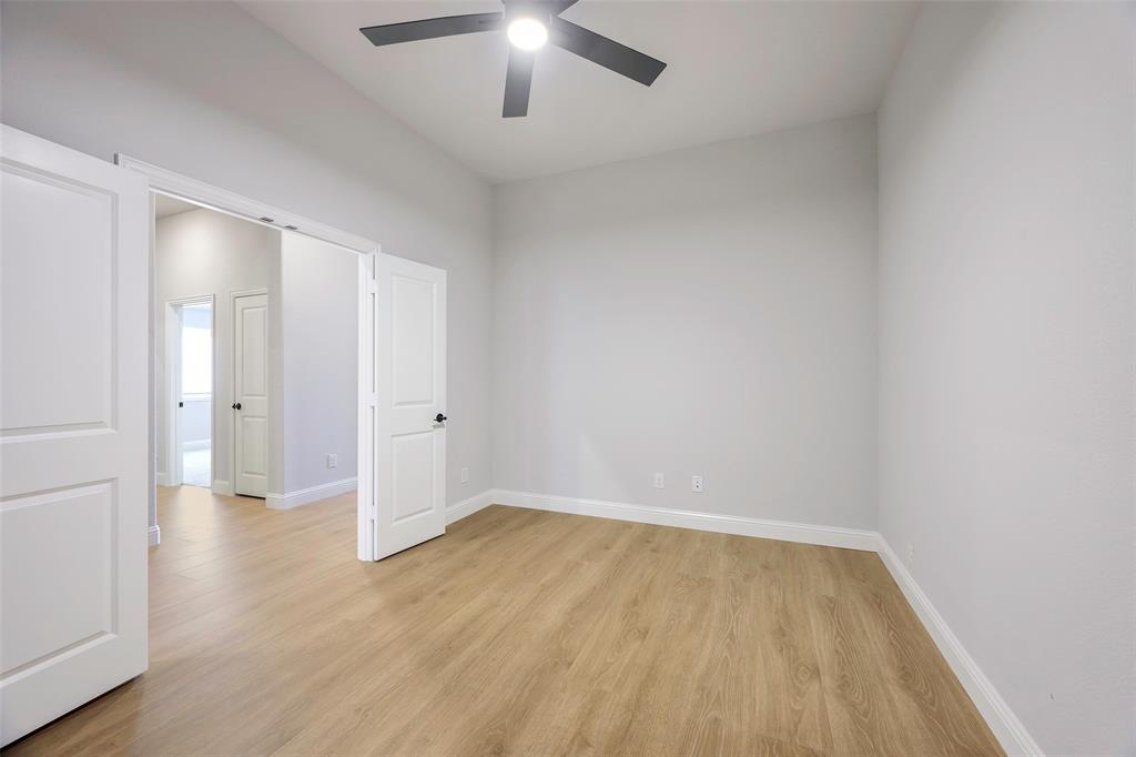 226 Comanche Trail Alvarado, TX 76009 - Photo 18 of 28 an empty room with wooden floor and chandelier fan