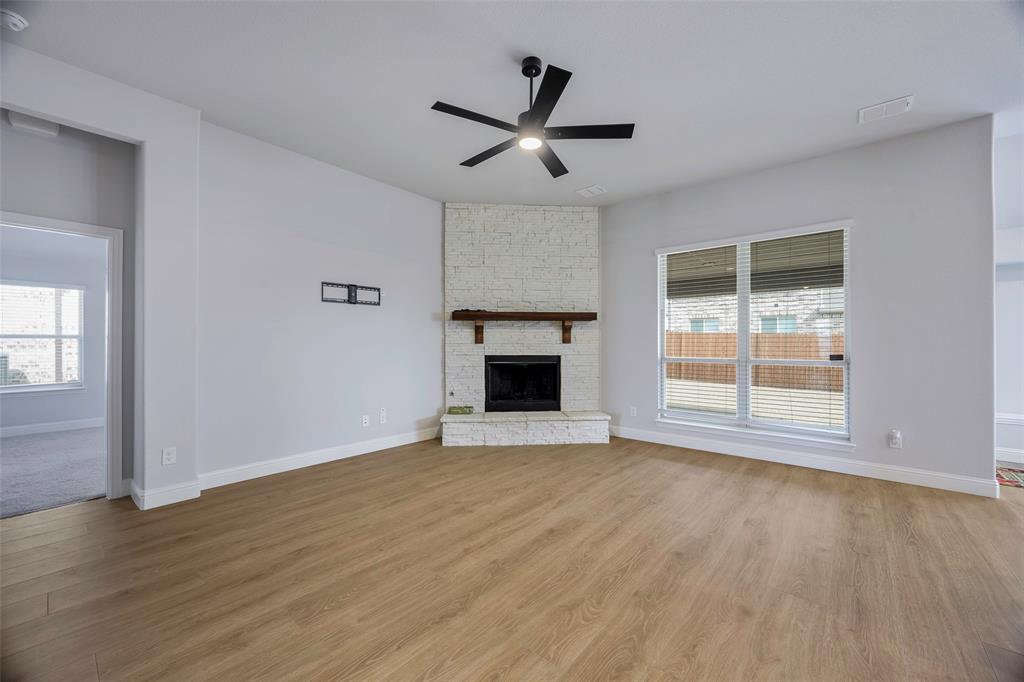 226 Comanche Trail Alvarado, TX 76009 - Photo 4 of 28 a view of an empty room with wooden floor and a window
