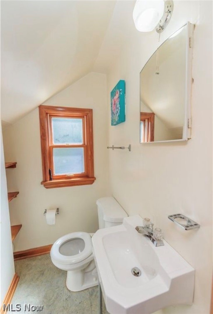 4521 Emerson Road South Euclid, OH 44121 - Photo 31 of 47 Bathroom featuring a built-in white sink, white toilet, and a medicine cabinet with mirrored door