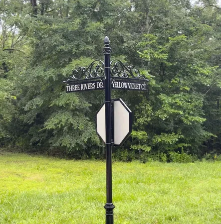 a sign board with tall trees