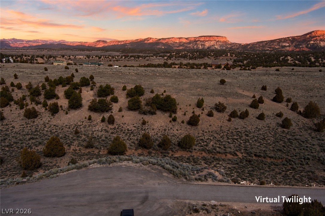 1825 Eagle Ridge Circle Hatch, UT 84735 - Photo 1 of 30 A vast, open lot with distant mountains bathed in the warm glow of a twilight sky.