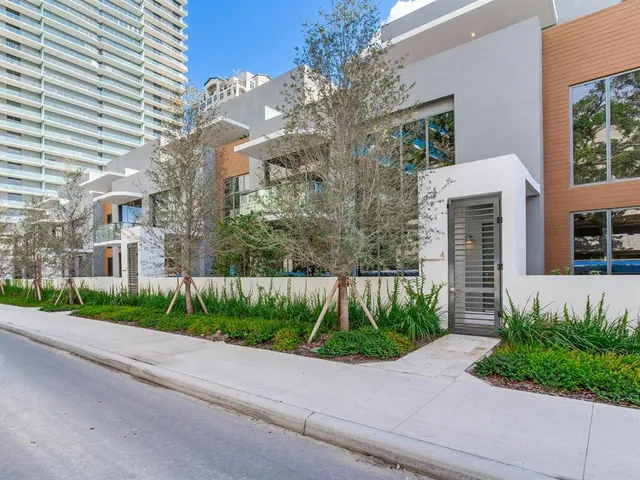 a front view of a house with a yard and potted plants