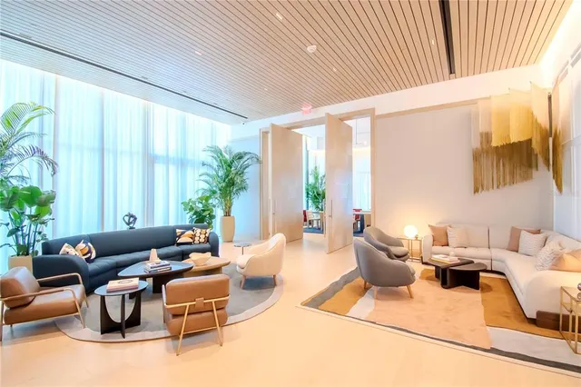 a living room with furniture a clock and a view of bathroom