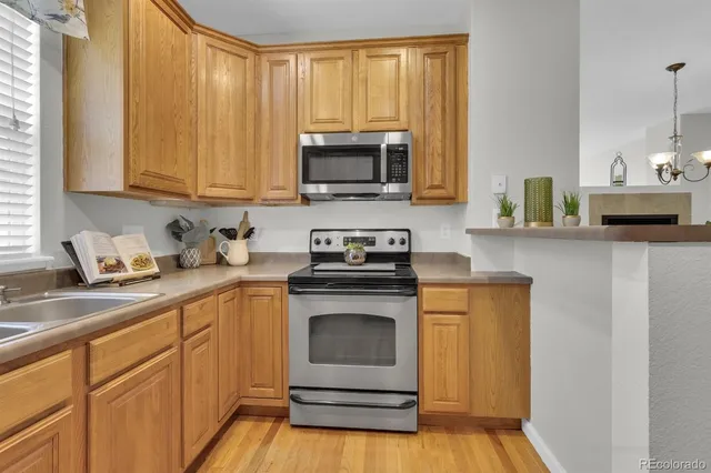 a kitchen with stainless steel appliances granite countertop a stove a sink and a microwave