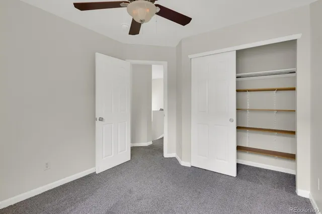 a view of an empty room with a ceiling fan