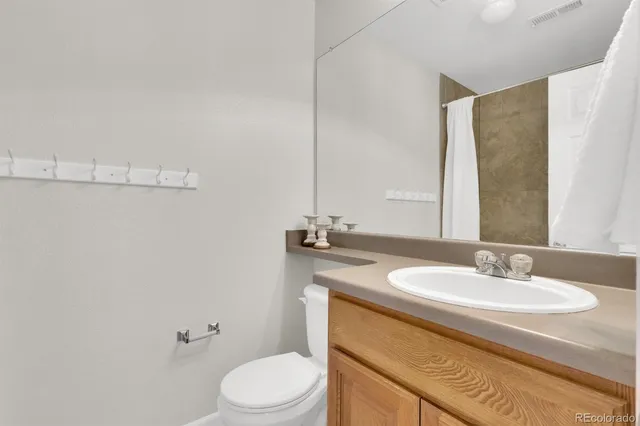 a bathroom with a sink toilet and mirror
