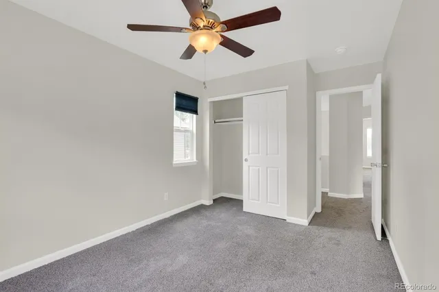 an empty room with closet and fan