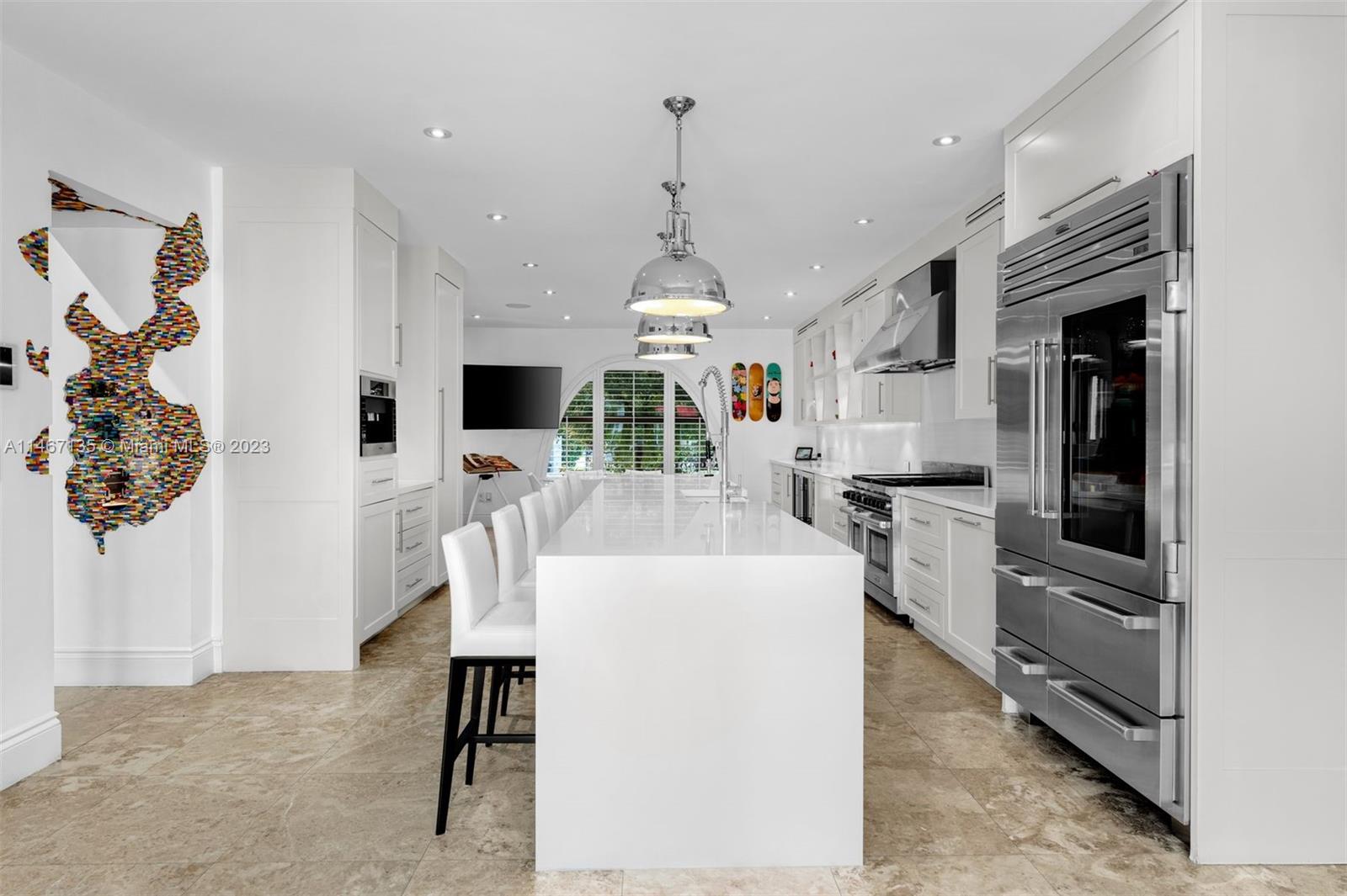 2201 Sunset Drive Miami Beach, FL 33140 - Photo 12 of 35 a kitchen with stainless steel appliances kitchen island granite countertop a stove top oven a sink a dining table and chairs