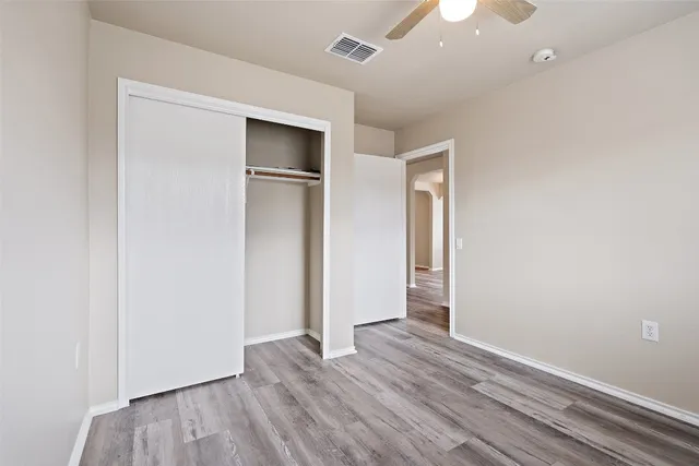 an empty room with wooden floor and closet