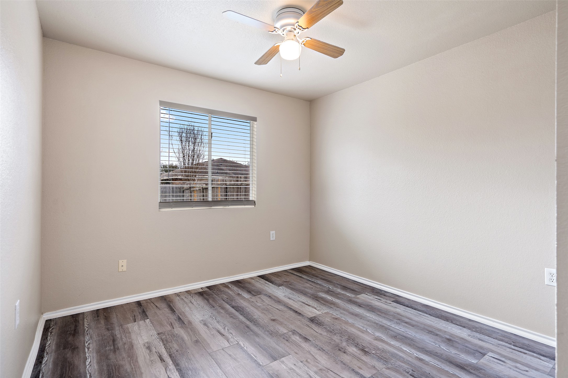 1617 Anise Drive Austin, TX 78741 - Photo 12 of 35 Empty room with wood finished floors and ceiling fan