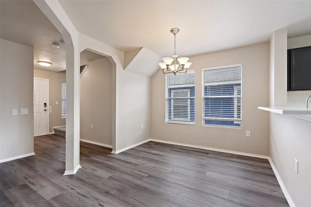 a view of livingroom with chandelier and wooden floor