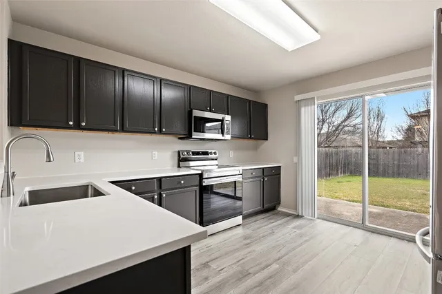 a kitchen that has a sink and a stove top oven
