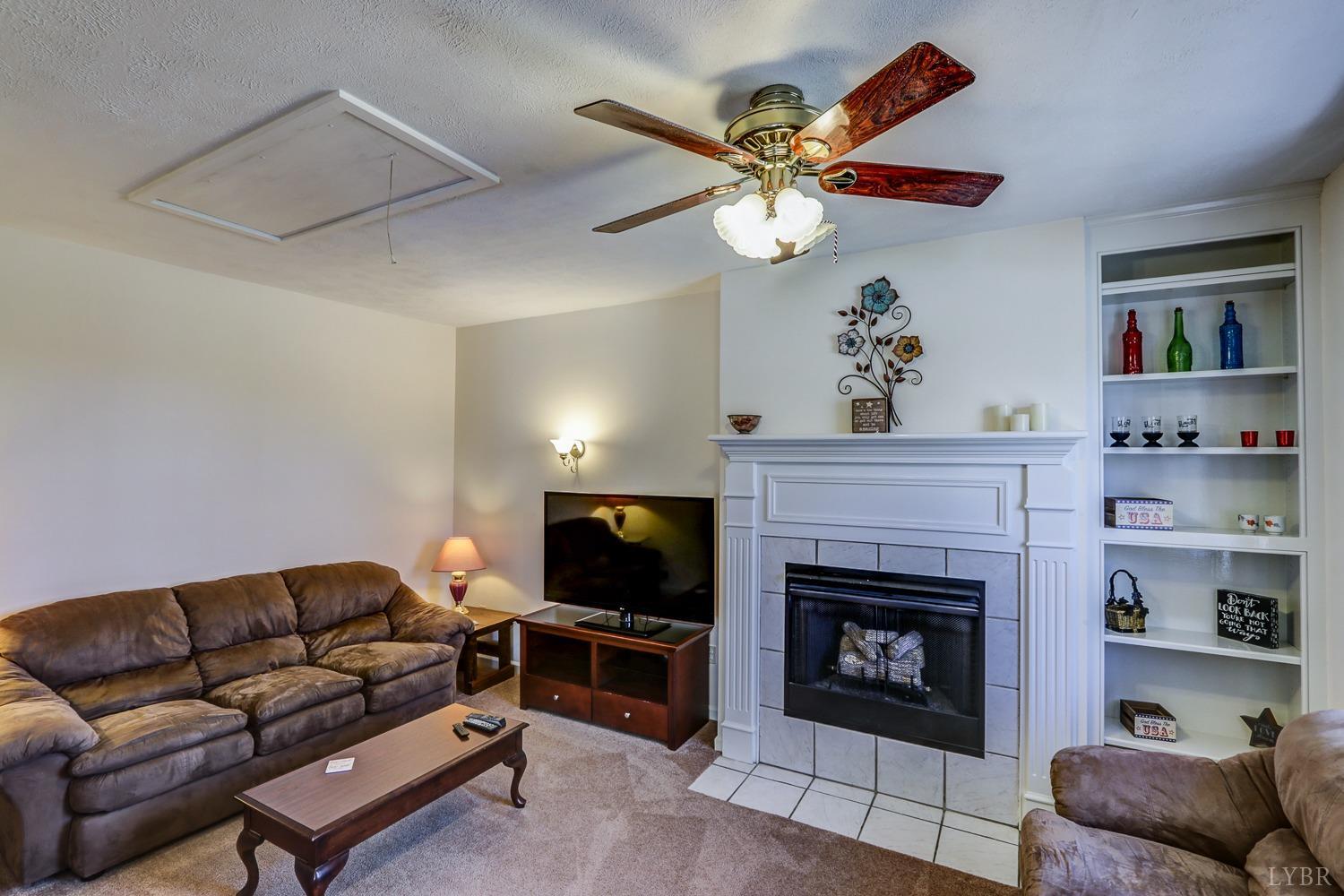 721 Doss Road Concord, VA 24538 - Photo 11 of 35 a living room with furniture a fireplace and a flat screen tv