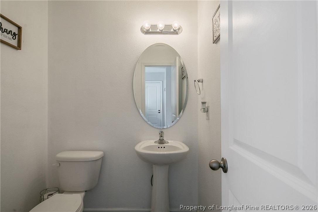 340 Battery Way Bunnlevel, NC 28323 - Photo 7 of 50 a bathroom with a toilet a sink and mirror