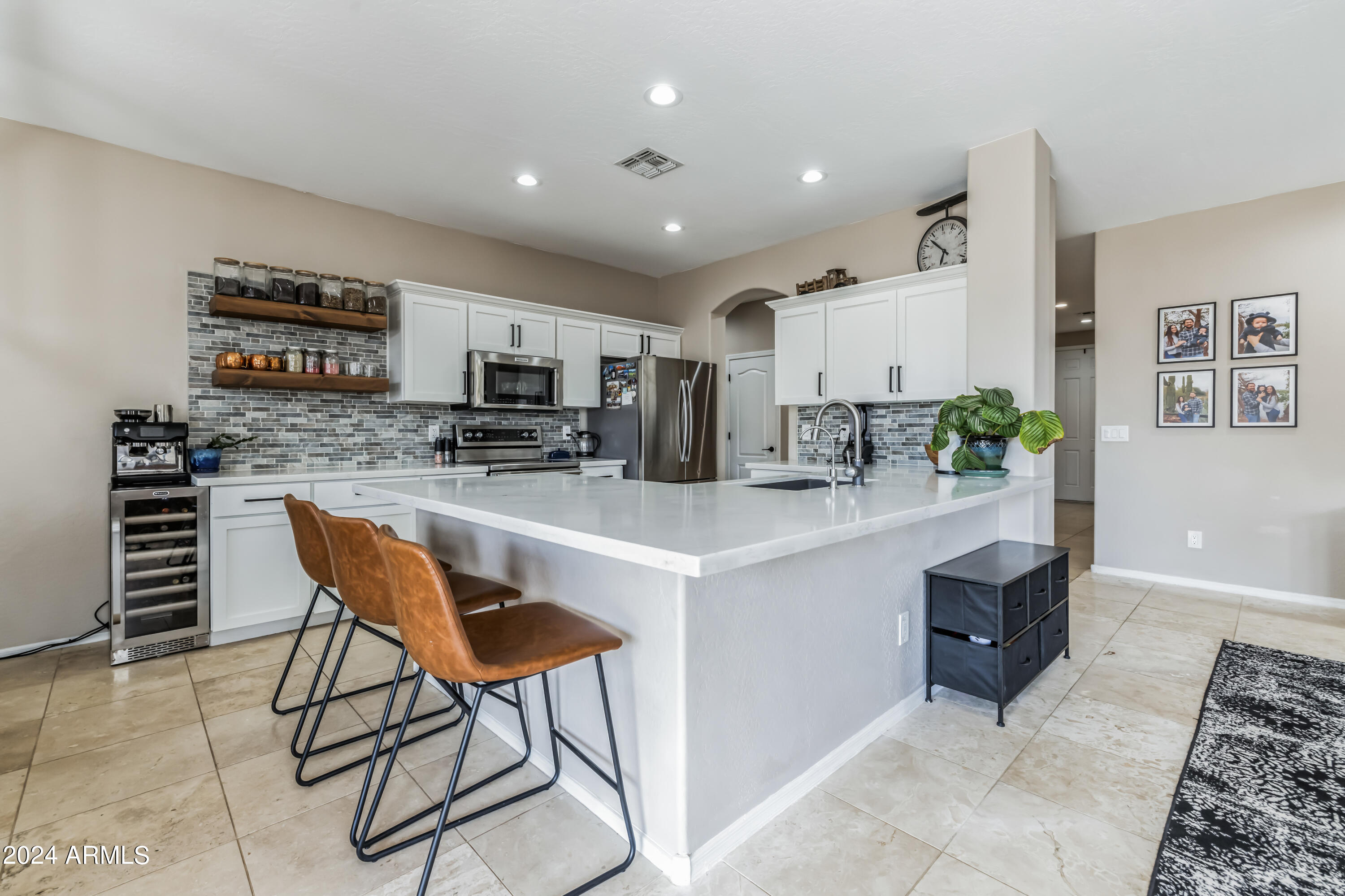 2535 South Martingale Road Gilbert, AZ 85295 - Photo 3 of 25 a kitchen with stainless steel appliances kitchen island granite countertop a refrigerator and a stove top oven