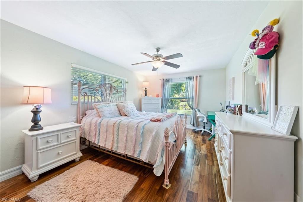 463 Torrey Pines Point Naples, FL 34113 - Photo 13 of 24 a bedroom with a bed and a chandelier