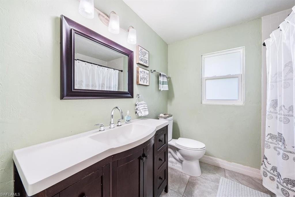 463 Torrey Pines Point Naples, FL 34113 - Photo 14 of 24 a bathroom with a sink a toilet and mirror