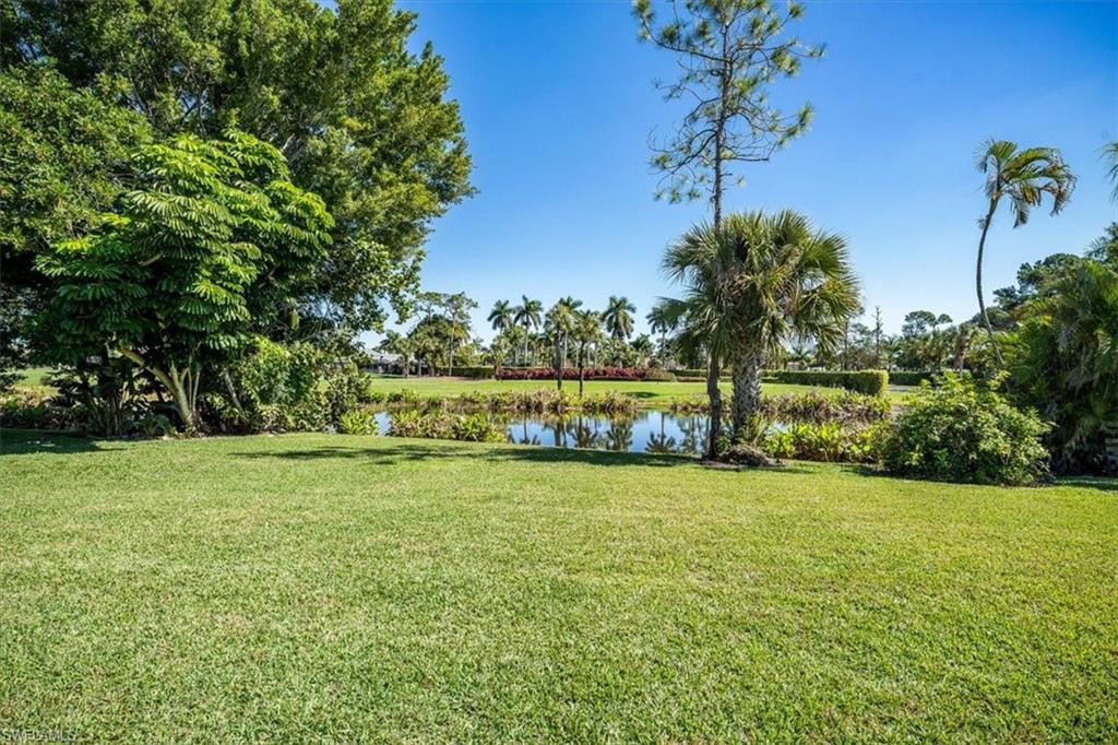 463 Torrey Pines Point Naples, FL 34113 - Photo 18 of 24 a view of a garden with a building in the background