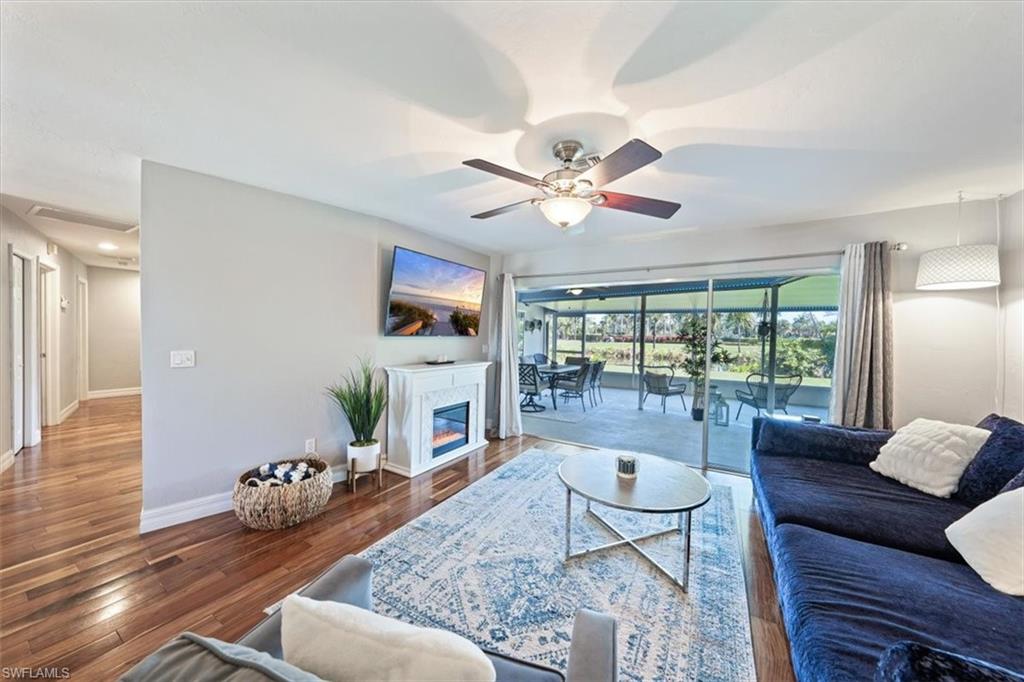 463 Torrey Pines Point Naples, FL 34113 - Photo 23 of 24 a living room with furniture a flat screen tv and a floor to ceiling window