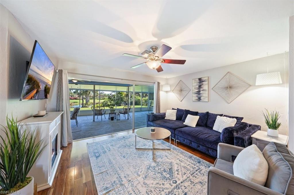463 Torrey Pines Point Naples, FL 34113 - Photo 3 of 24 a living room with furniture a flat screen tv and a large window