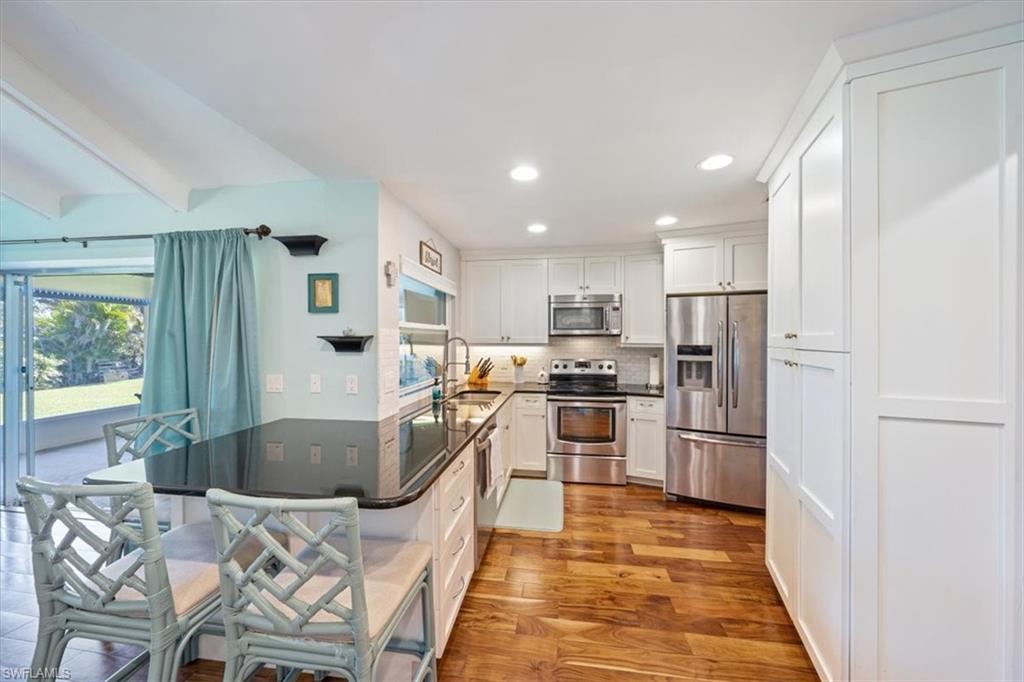 463 Torrey Pines Point Naples, FL 34113 - Photo 5 of 24 a kitchen with stainless steel appliances granite countertop a refrigerator and a stove top oven