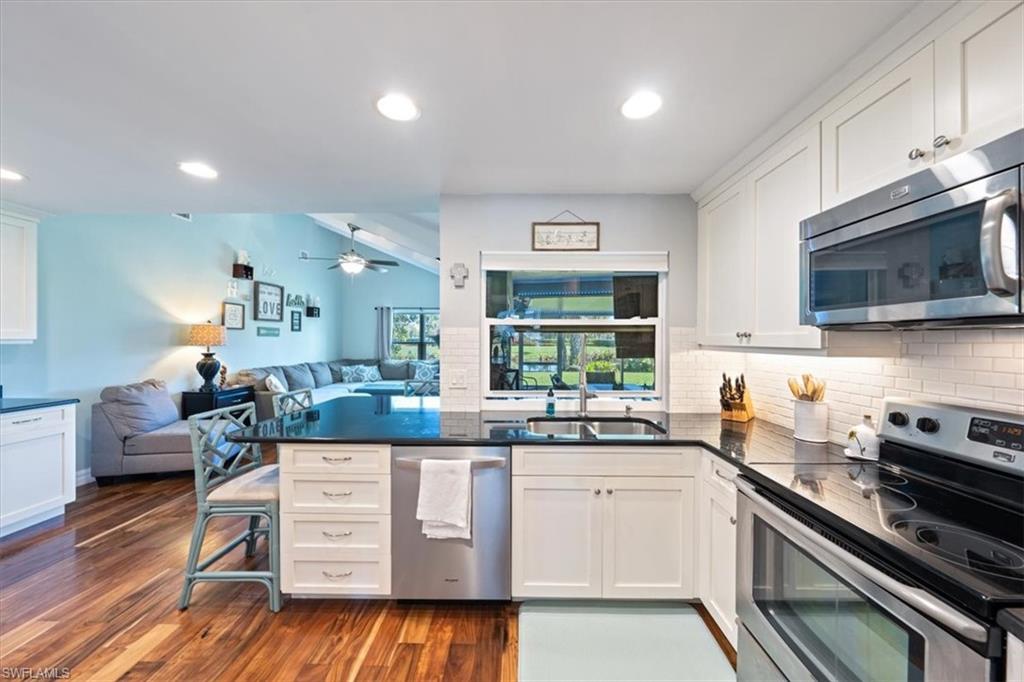 463 Torrey Pines Point Naples, FL 34113 - Photo 6 of 24 a kitchen with stainless steel appliances granite countertop a stove and cabinets