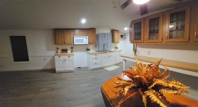 a kitchen with a sink cabinets and wooden floor
