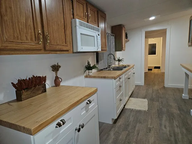 a kitchen with stainless steel appliances a sink cabinets and wooden floor