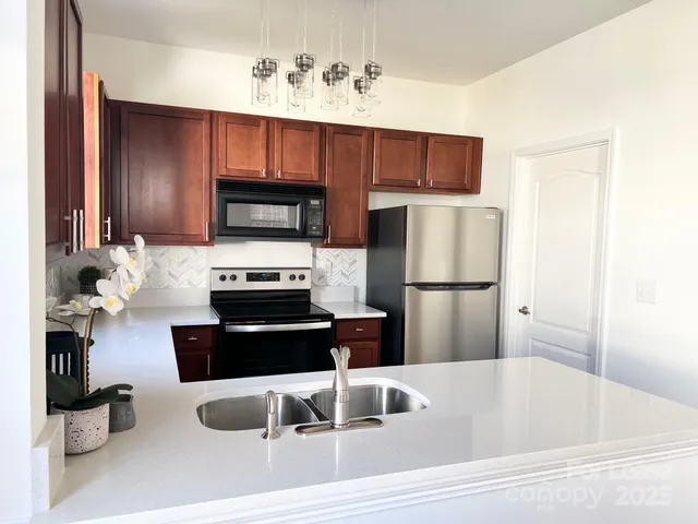 a kitchen with a refrigerator and a stove top oven