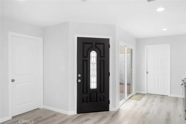 an empty room with wooden floor mirror and windows