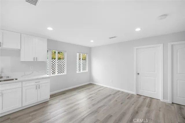 a view of a kitchen with wooden floor and electronic appliances
