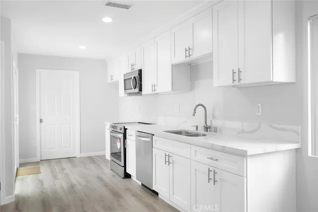 a kitchen with white cabinets sink and dishwasher
