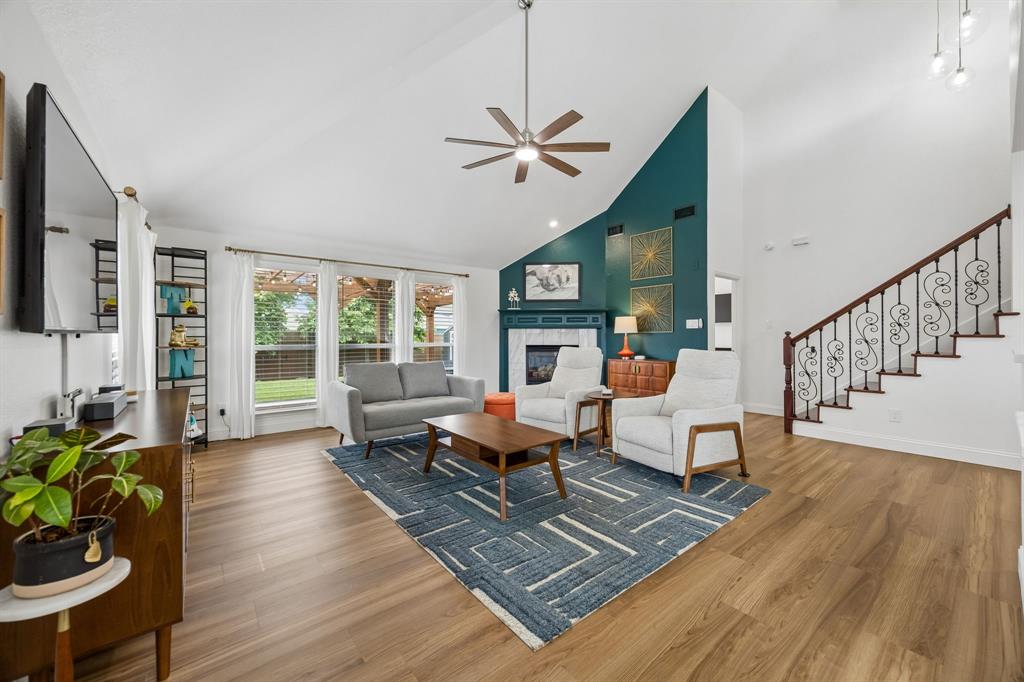 9217 Inverness Drive Rowlett, TX 75089 - Photo 11 of 40 Open Family Room with Vaulted Ceilings — The family room brings together soaring ceilings, LVP flooring, updated lighting, and backyard views for a comfortable space that feels both open and connected.