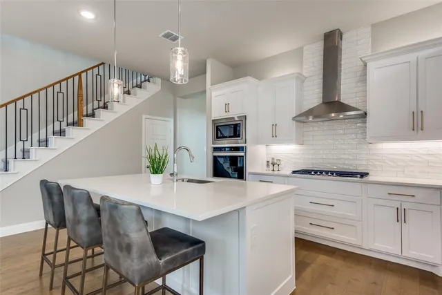 a kitchen with stainless steel appliances kitchen island a stove a table and chairs