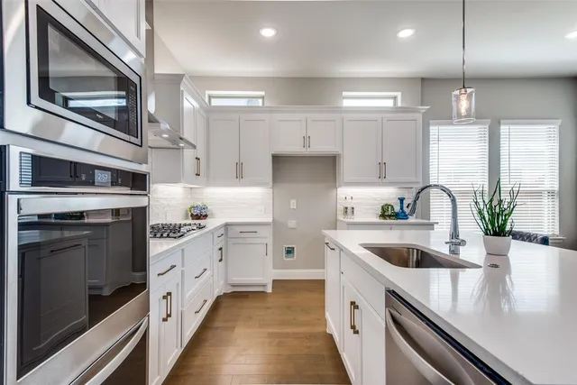 a kitchen with granite countertop a sink stainless steel appliances and cabinets