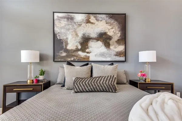 a bedroom with furniture and a lamp on dresser