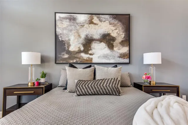 a bedroom with furniture and a lamp on dresser