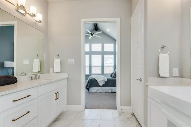 a en suite bathroom with a double vanity sink and a mirror