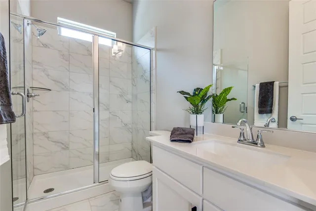 a bathroom with a shower sink and toilet