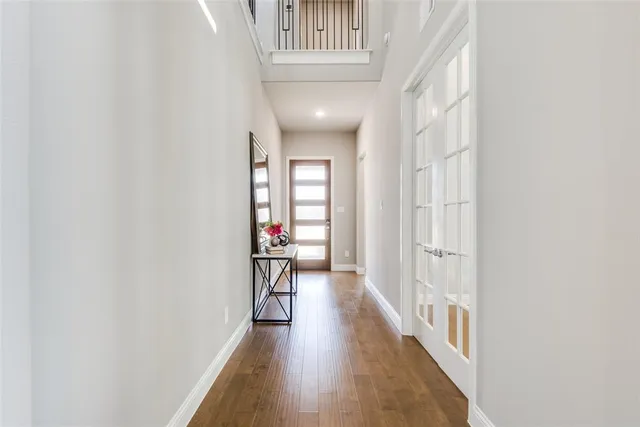 a view of a hallway with wooden floor and windows