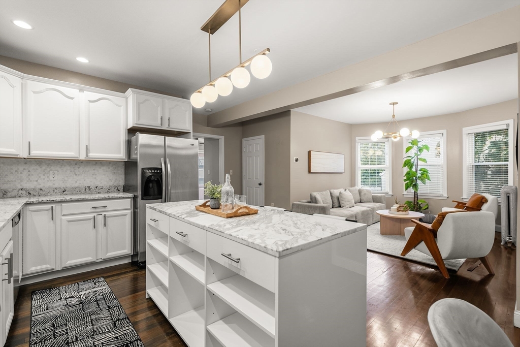 a open kitchen with stainless steel appliances granite countertop a stove refrigerator and cabinets