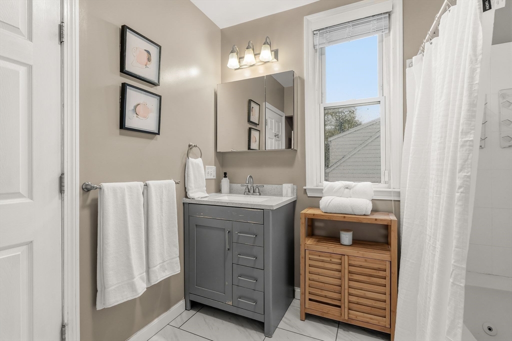 77 Wheatland Street, Unit 2 Somerville, MA 02145 - Photo 4 of 20 a bathroom with a double vanity sink mirror and