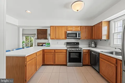 a kitchen with stainless steel appliances granite countertop a stove sink and cabinets