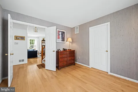 a view of a livingroom with wooden floor and kitchen