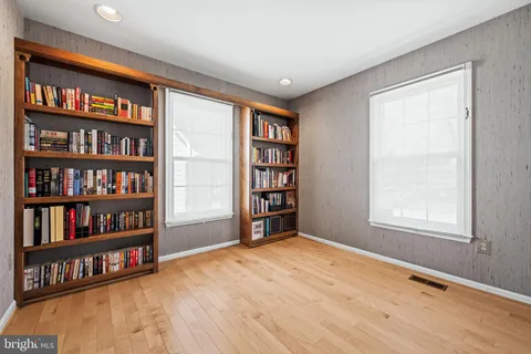 a big room with windows book shelf and a window