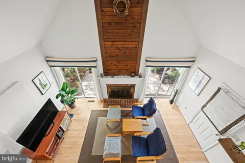 a living room with furniture a fireplace and a floor to ceiling window