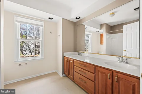 a spacious bathroom with a granite countertop sink a mirror a and a window