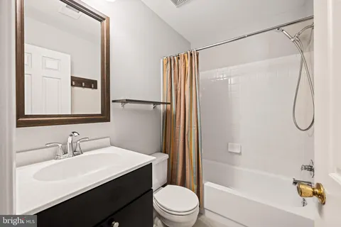 a bathroom with a sink vanity mirror and toilet